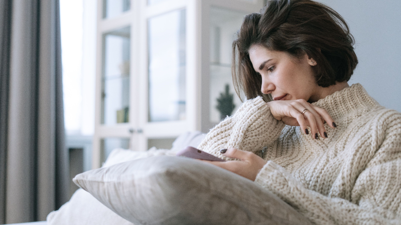  femme qui regarde son téléphone avec une expression préoccupée, ghosting