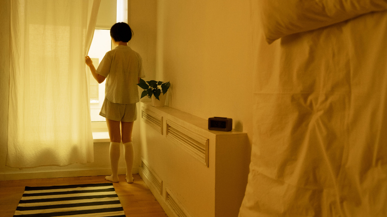  femme assise seule qui regarde par la fenêtre, sortir de la dépendance affective