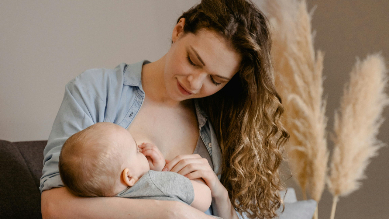 A breastfeeding mother looking empowered and confident while nursing her baby