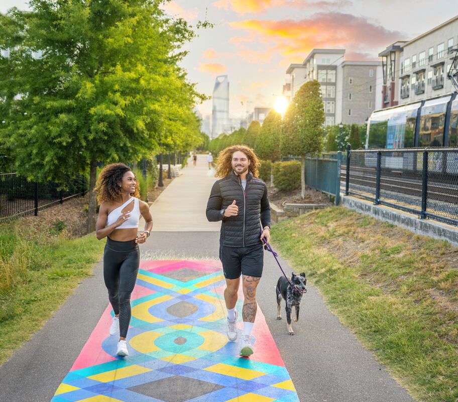 Two people walking the South End Rail Trail at sunrise