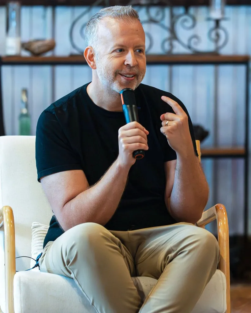 Kyle Cease, mid-conversation with a microphone at a live event