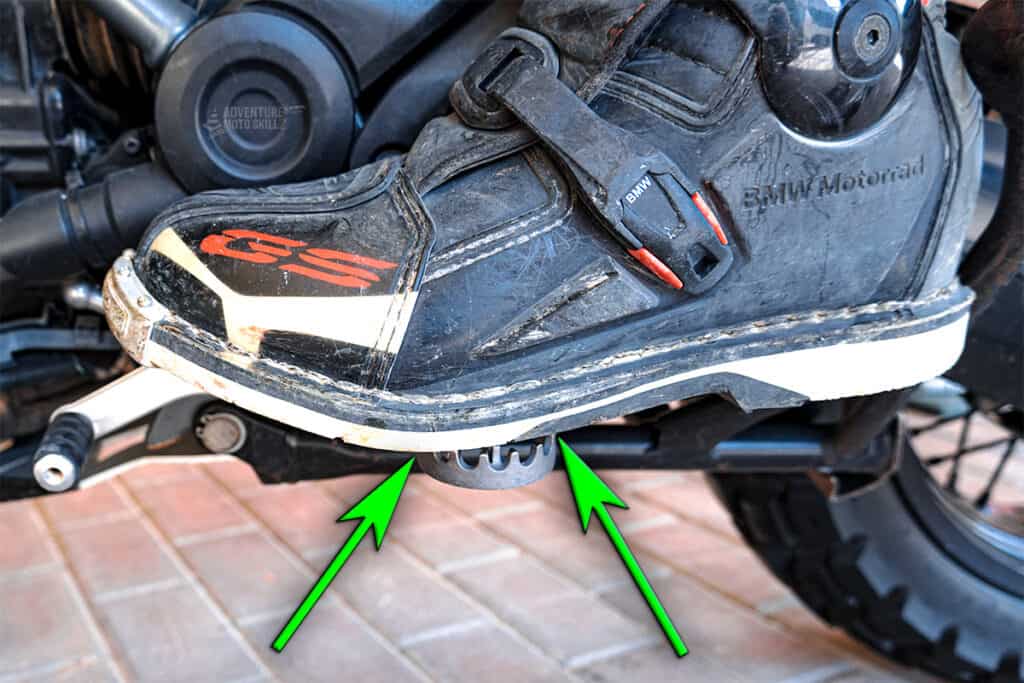 Motorcycle boot on the peg between the base of the ball and the front of the arch