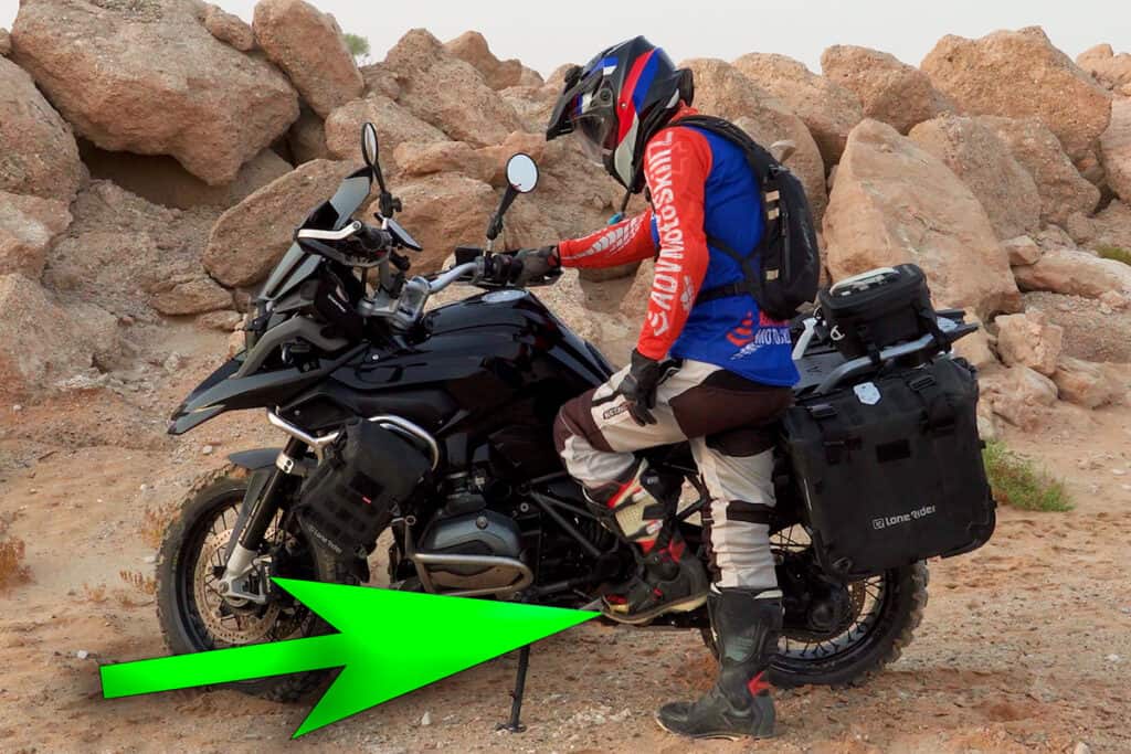 Rider using the foot peg to mount an ADV motorcycle