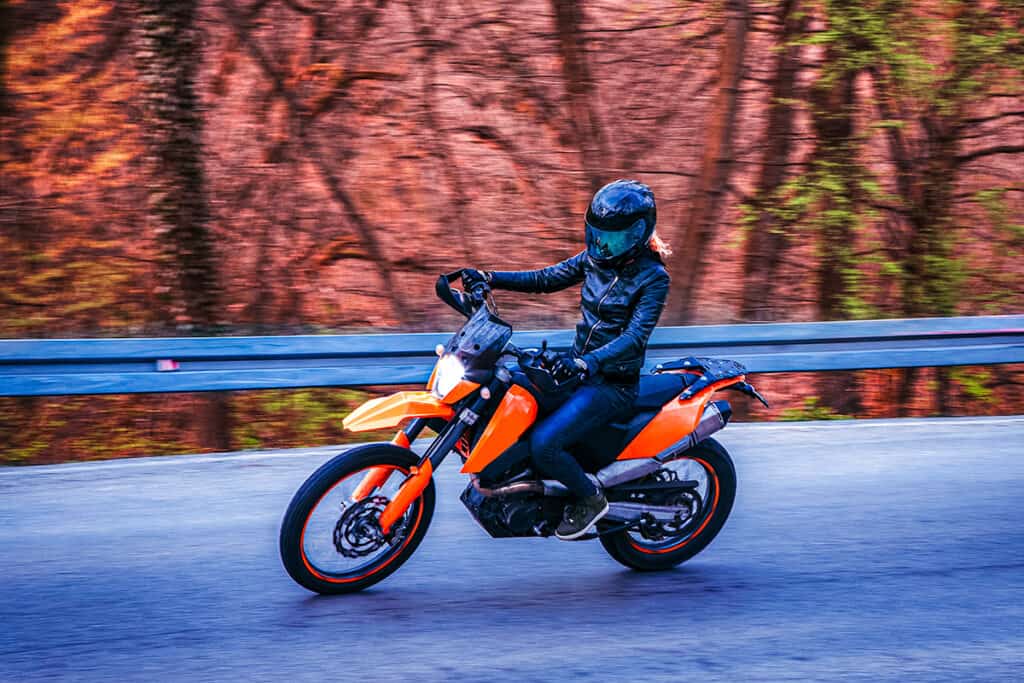 Dual-sport motorcycle riding on asphalt