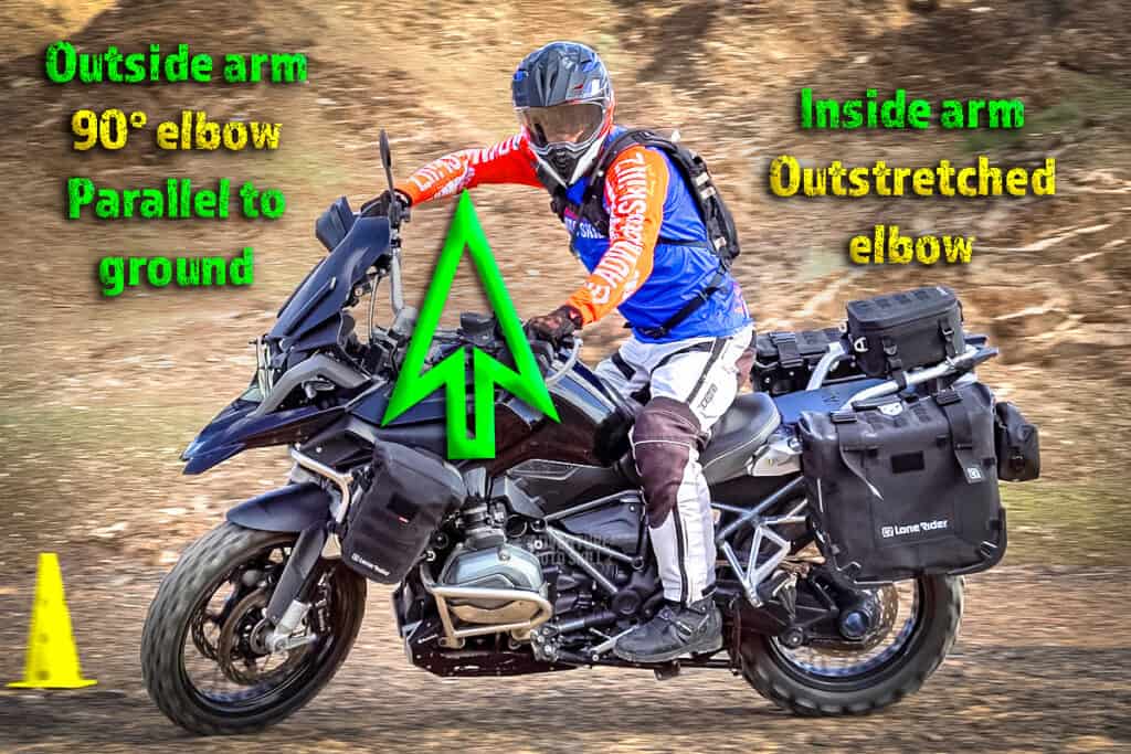 Proper cornering body posture with the outside elbow out wide on an off-road motorcycle