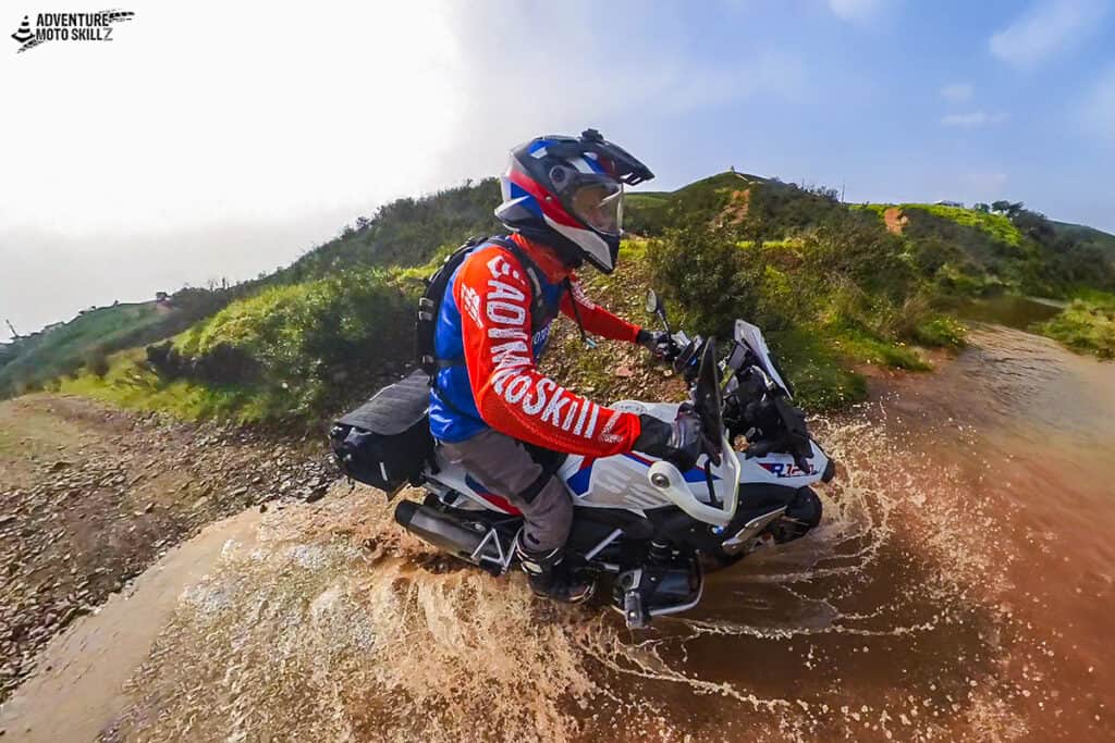 BMW adventure motorcycle rider in an attack position crossing water
