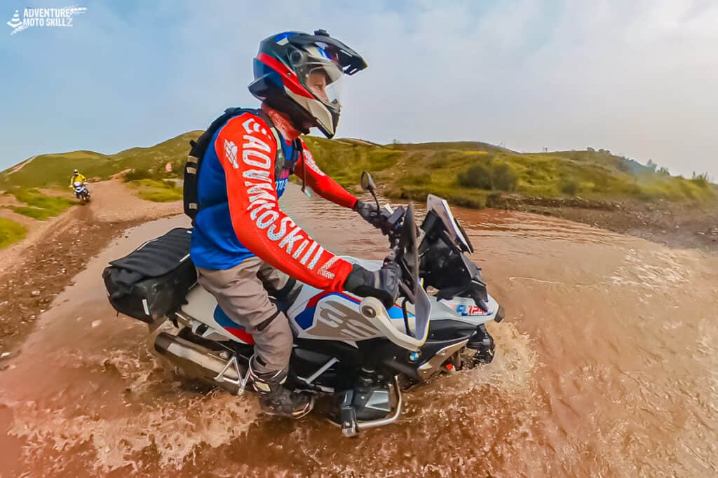 BMW adventure motorcycle riding through a water crossing