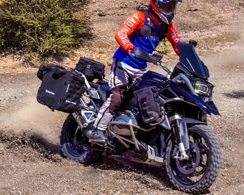 Rider on a BMW R1200GS motorcycle showing good balance while riding off-road in gravel