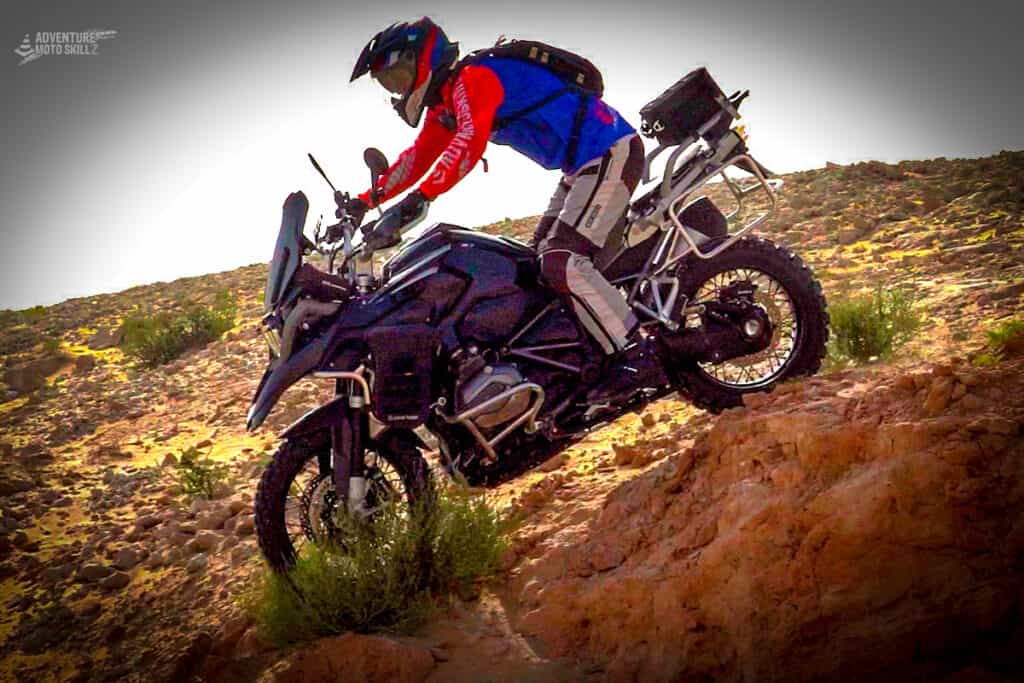 Adventure motorcycle riding down an off-road hill
