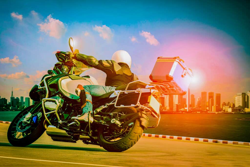 Motorcycle riding on asphalt with a cityscape background