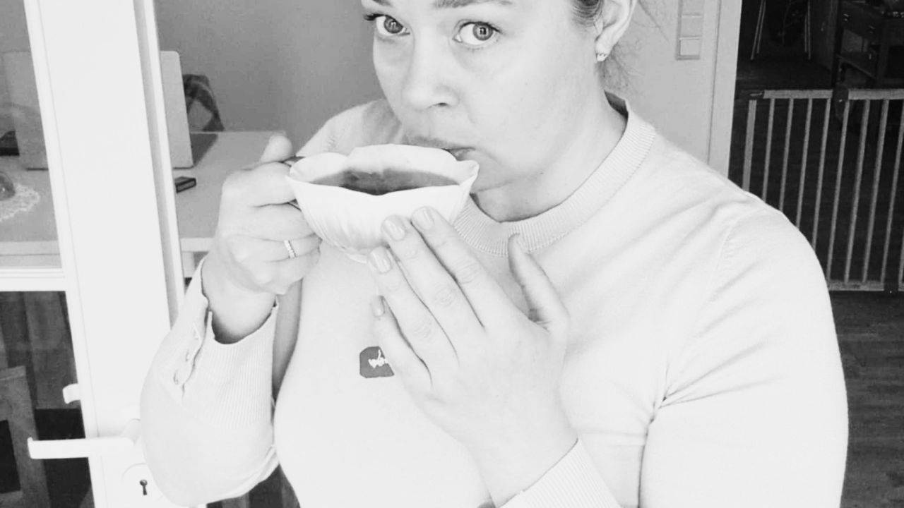 Sandra Törnroth drinking tea from a white cup at home