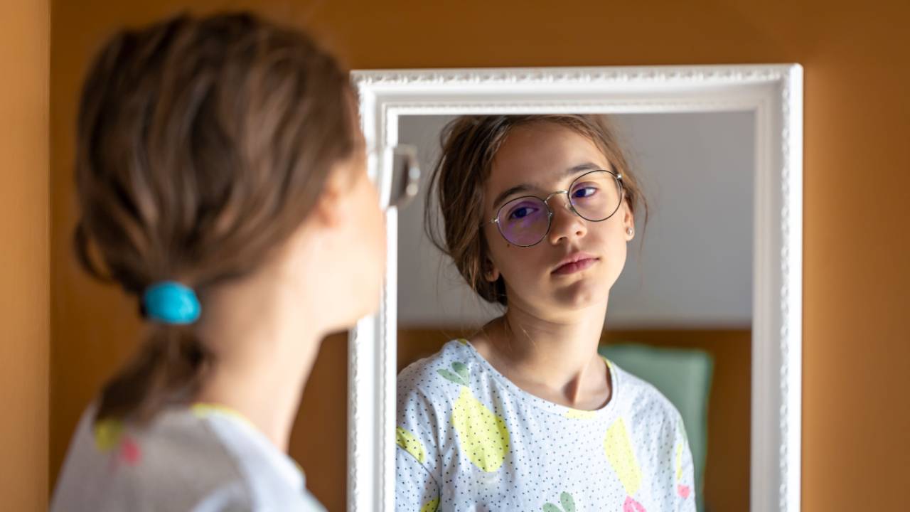 Jeune fille devant un miroir pour illustrer l’image corporelle chez les enfants