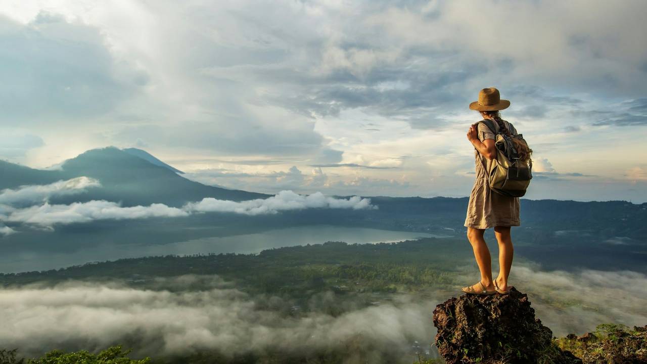 Woman standing on top of mountain overlooking landscape
