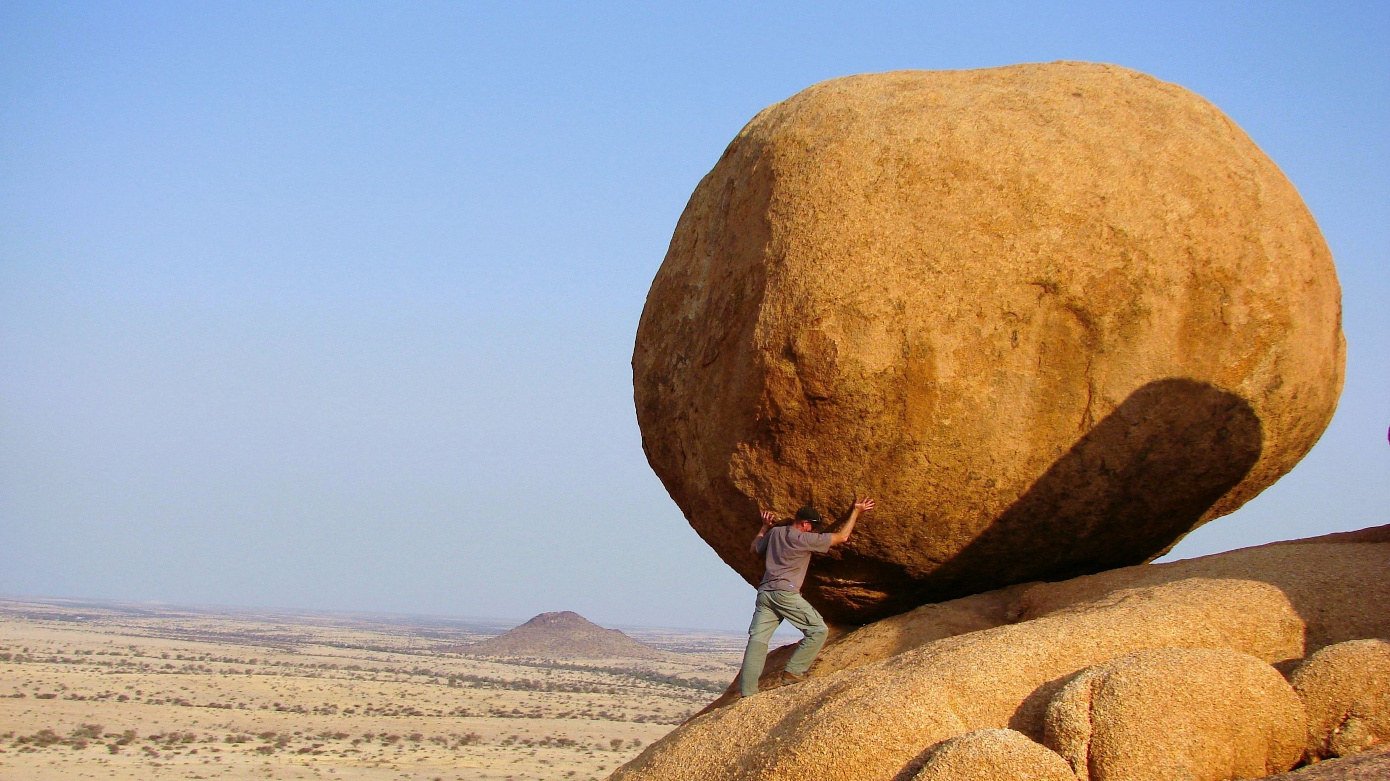 Man holding up giant boulder
