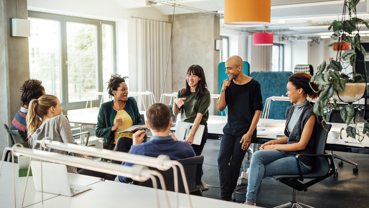 Diverse team of professionals collaborating in a modern workplace during a leadership development discussion.