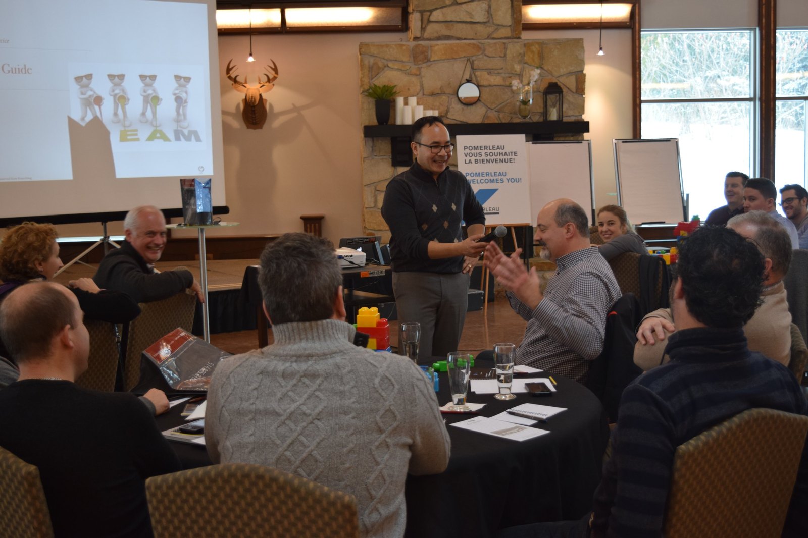 Tito Kang facilitating a leadership workshop, with participants laughing around round tables