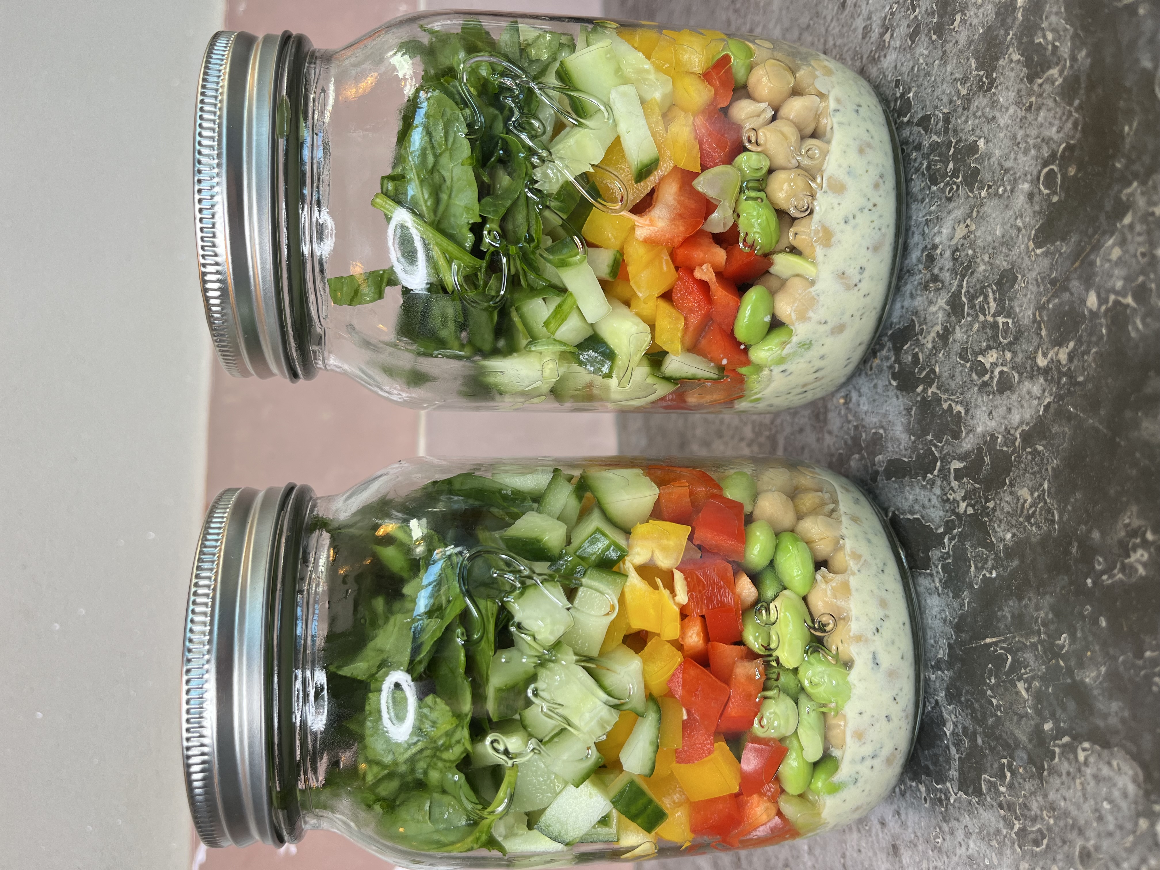 Saladepotten met groente, peulvruchten en dressing