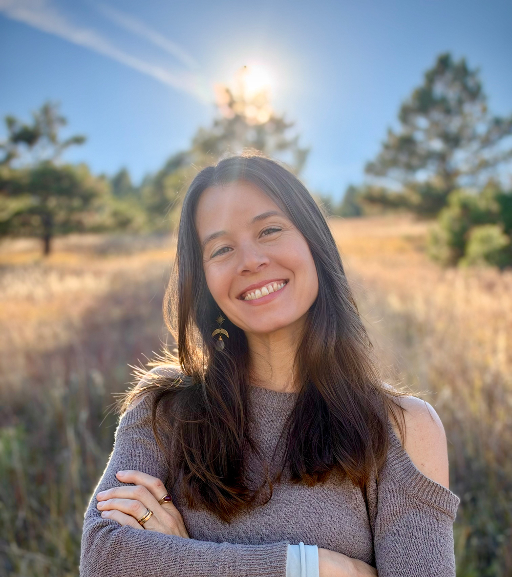 Dayna Seraye smiling in a sunlit meadow