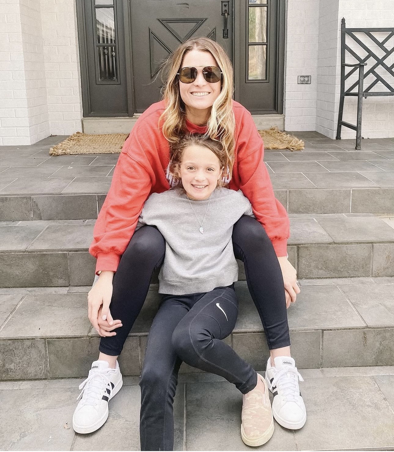 Jess sitting on the front steps with her daughter