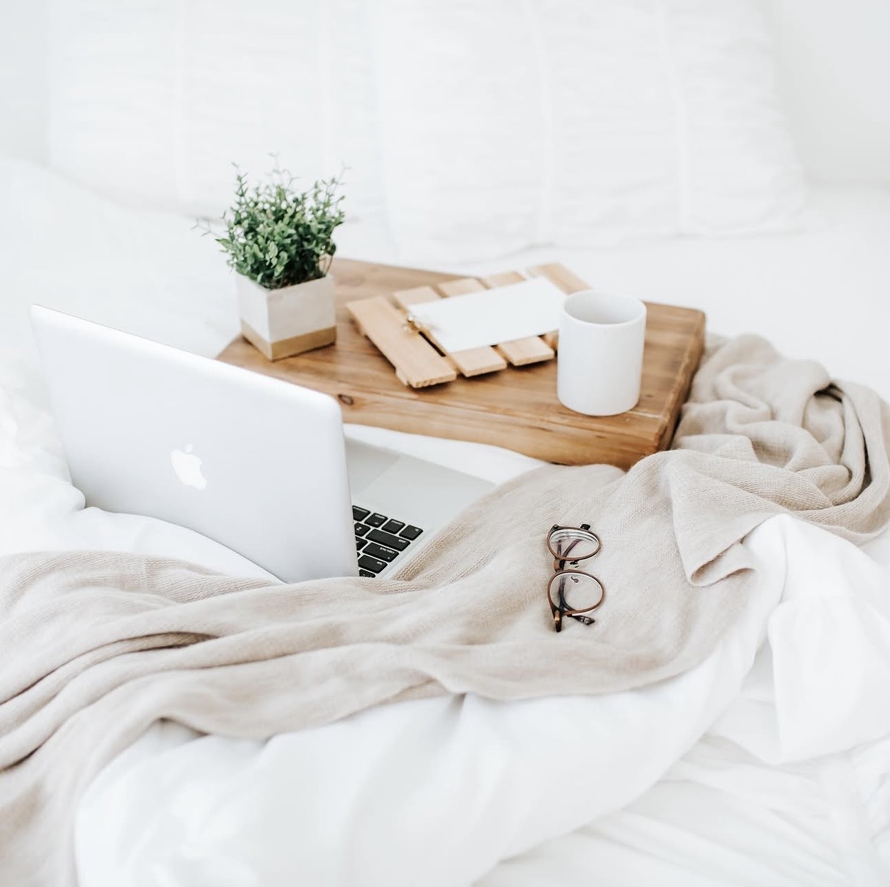 A laptop on a cozy blanket with coffee