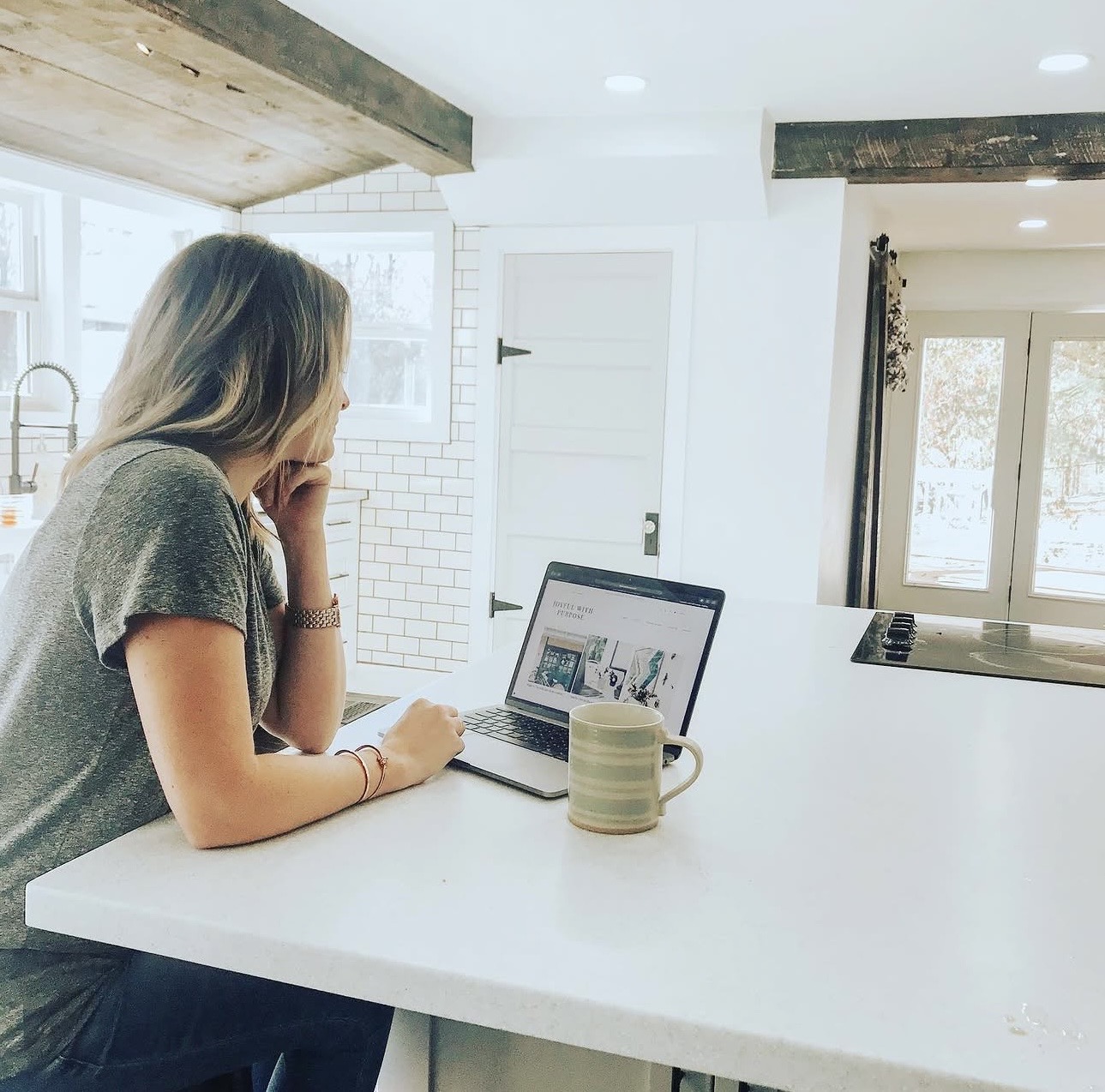 Jess working on her laptop at the kitchen counter