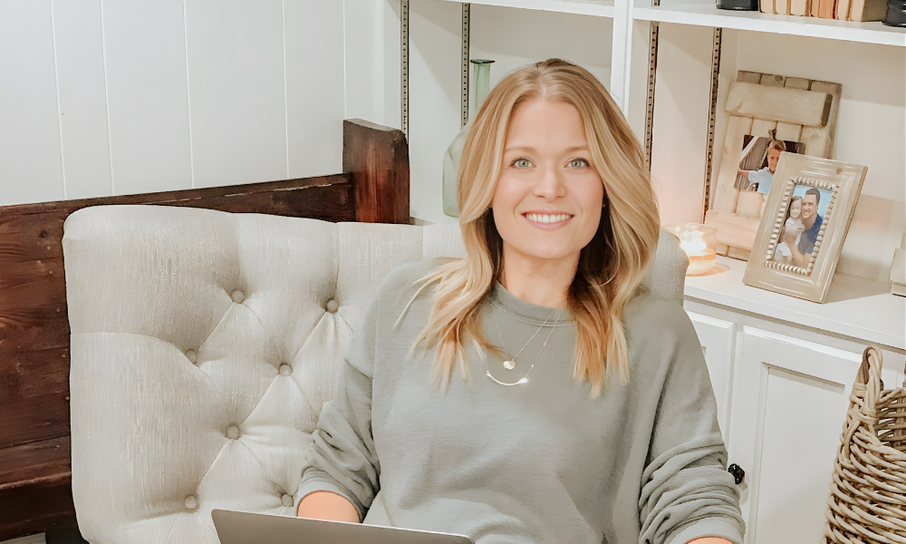 Jess smiling in a tufted chair at home