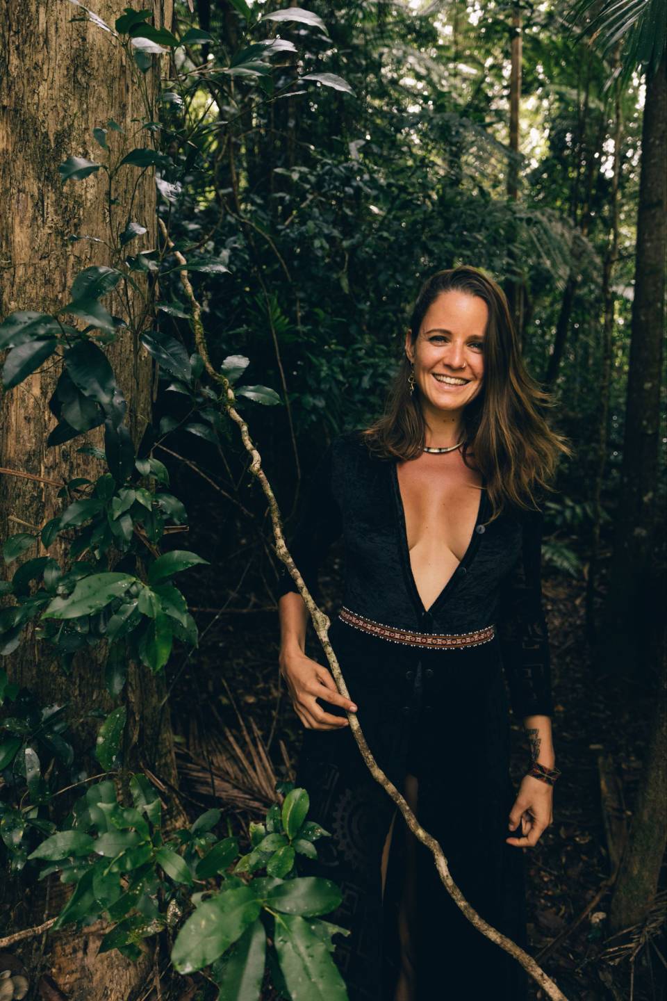 Sophie Saemrow smiling beside a tree in the forest.