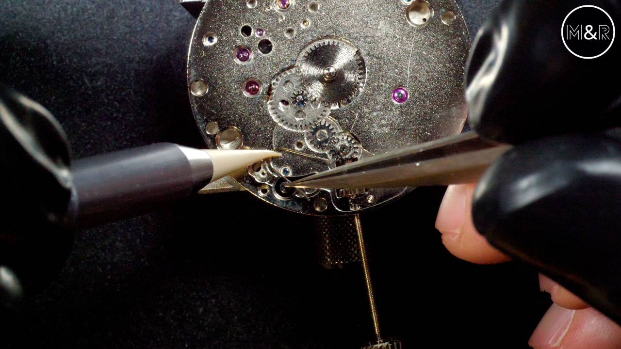 Gros plan d'un mouvement mécanique en cours de réglage — formation horlogerie à distance