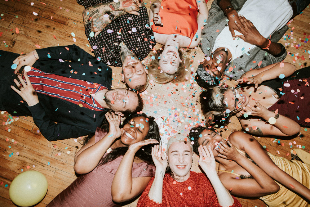 People laying in a circle with confettie