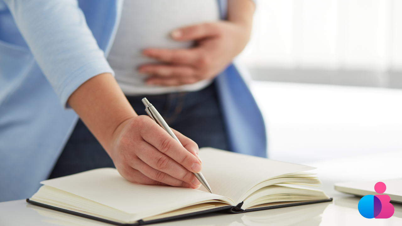 Expecting parent writing questions in a notebook before a prenatal appointment