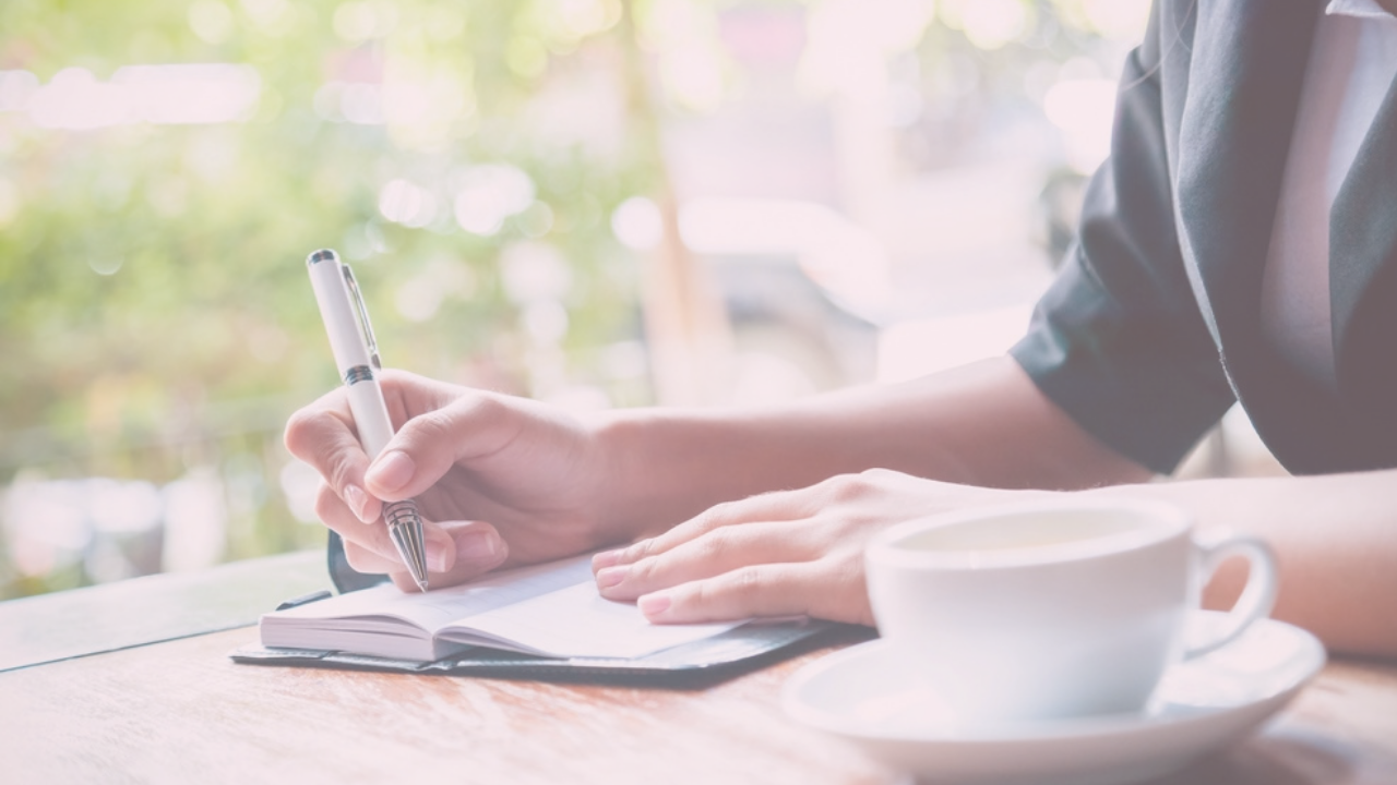 Woman tracking menstrual cycle changes during perimenopause in a journal