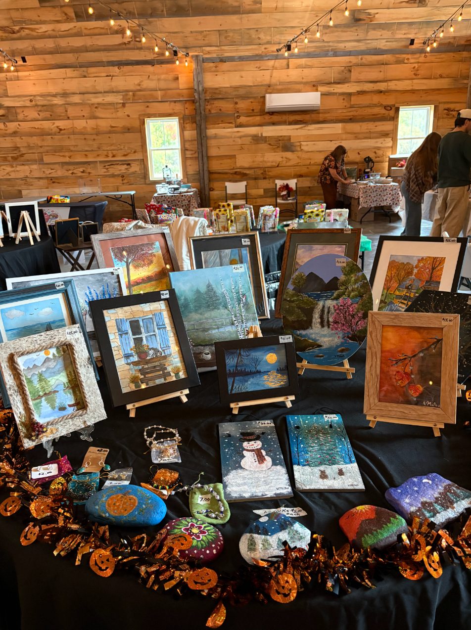 A craft fair table displaying framed watercolors