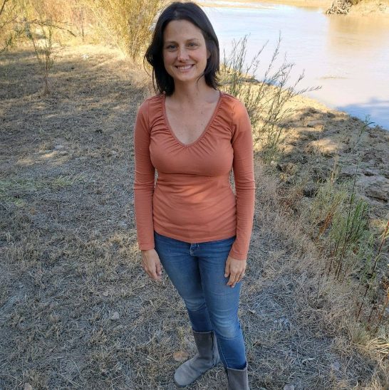 Megan Igo, standing outdoors by a river