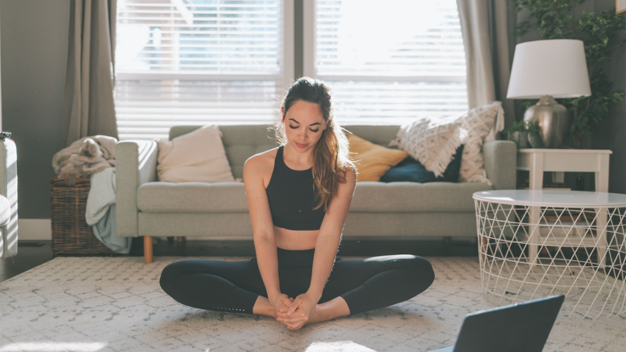 Woman stretching in her living room between work sessions on her laptop." That helps both search and screen readers.