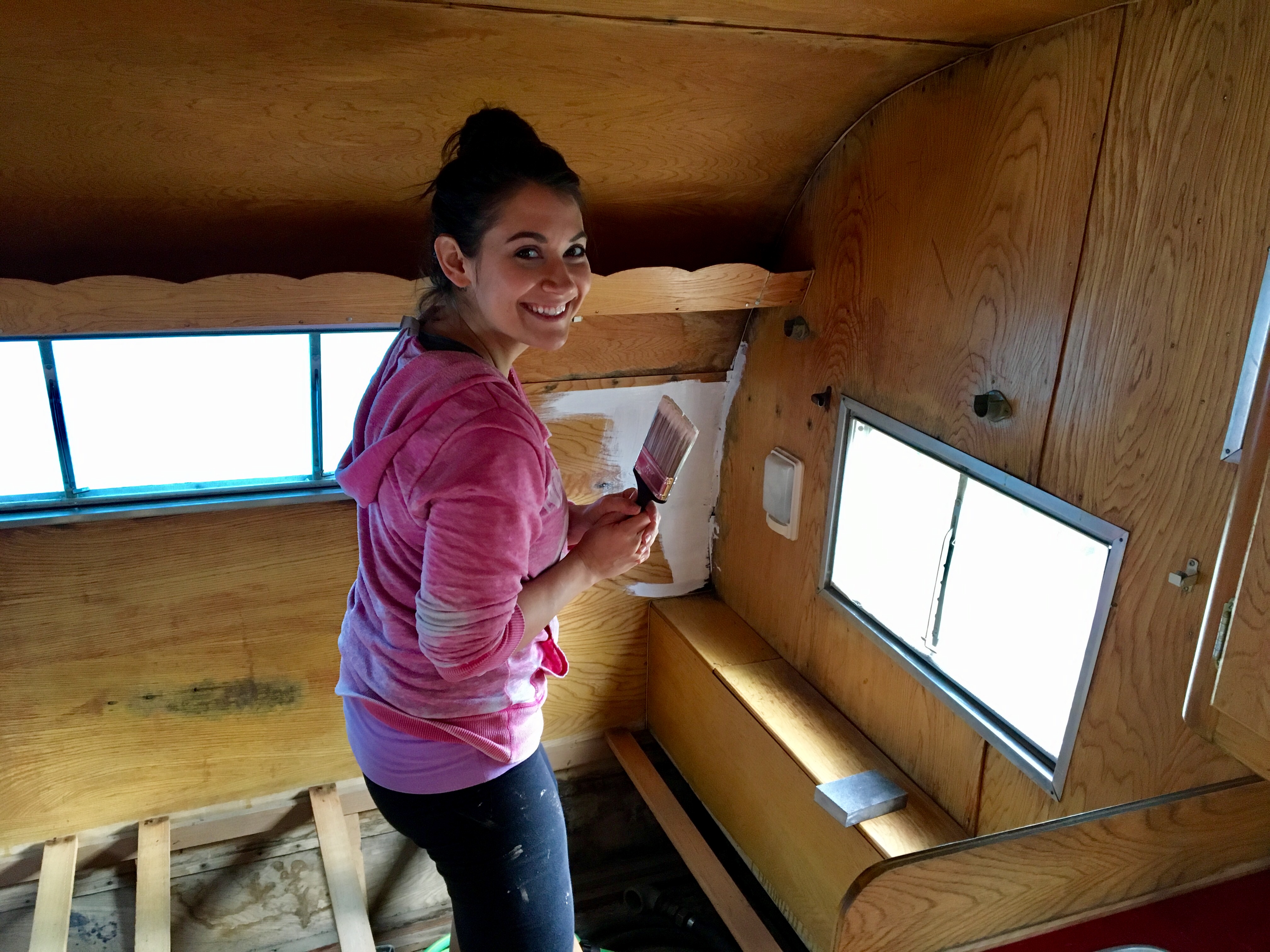 Jenna painting the interior of the vintage camper mid-renovation