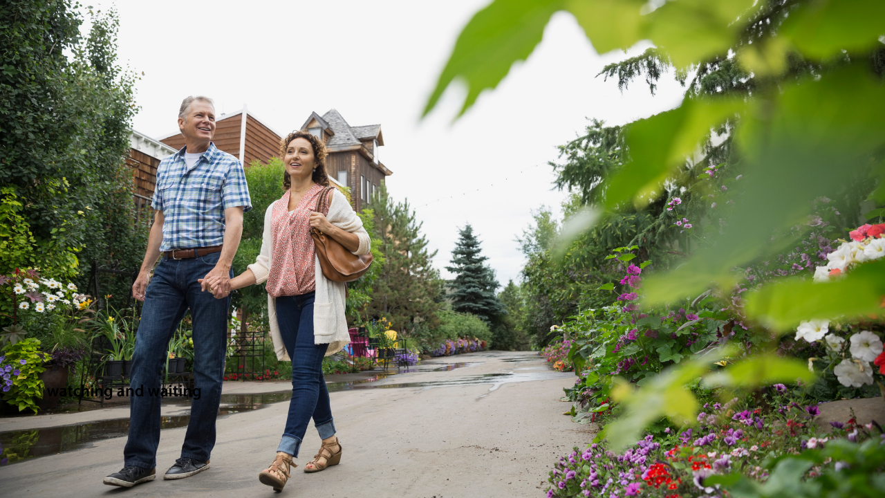 Middle-aged couple walking hand in hand outdoors on a garden path, representing support, resilience, and quality of life after a prostate cancer diagnosis.