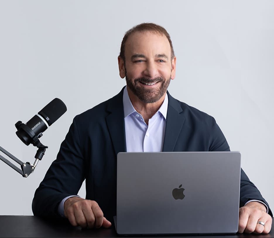Dr. Stephen Petteruti sitting at a desk with a laptop in front of him ready to do a podcast
