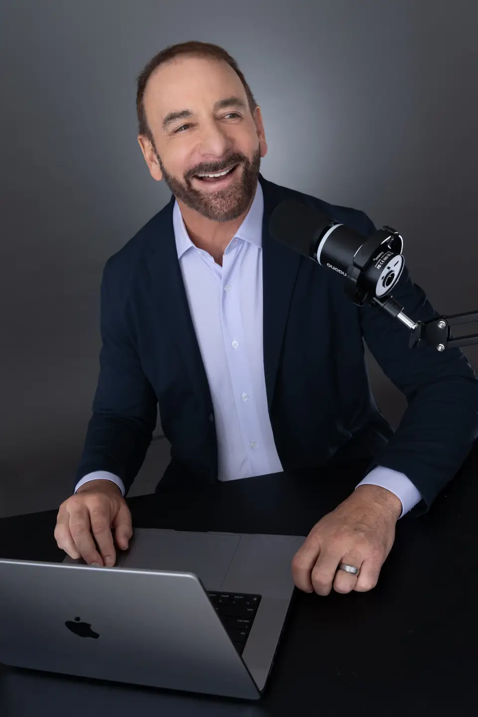 Dr. Stephen Petteruti smiling, working on a laptop.