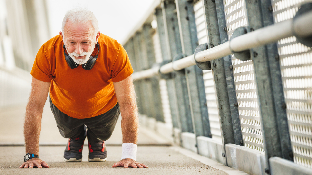 Older man in a plank position, smiling