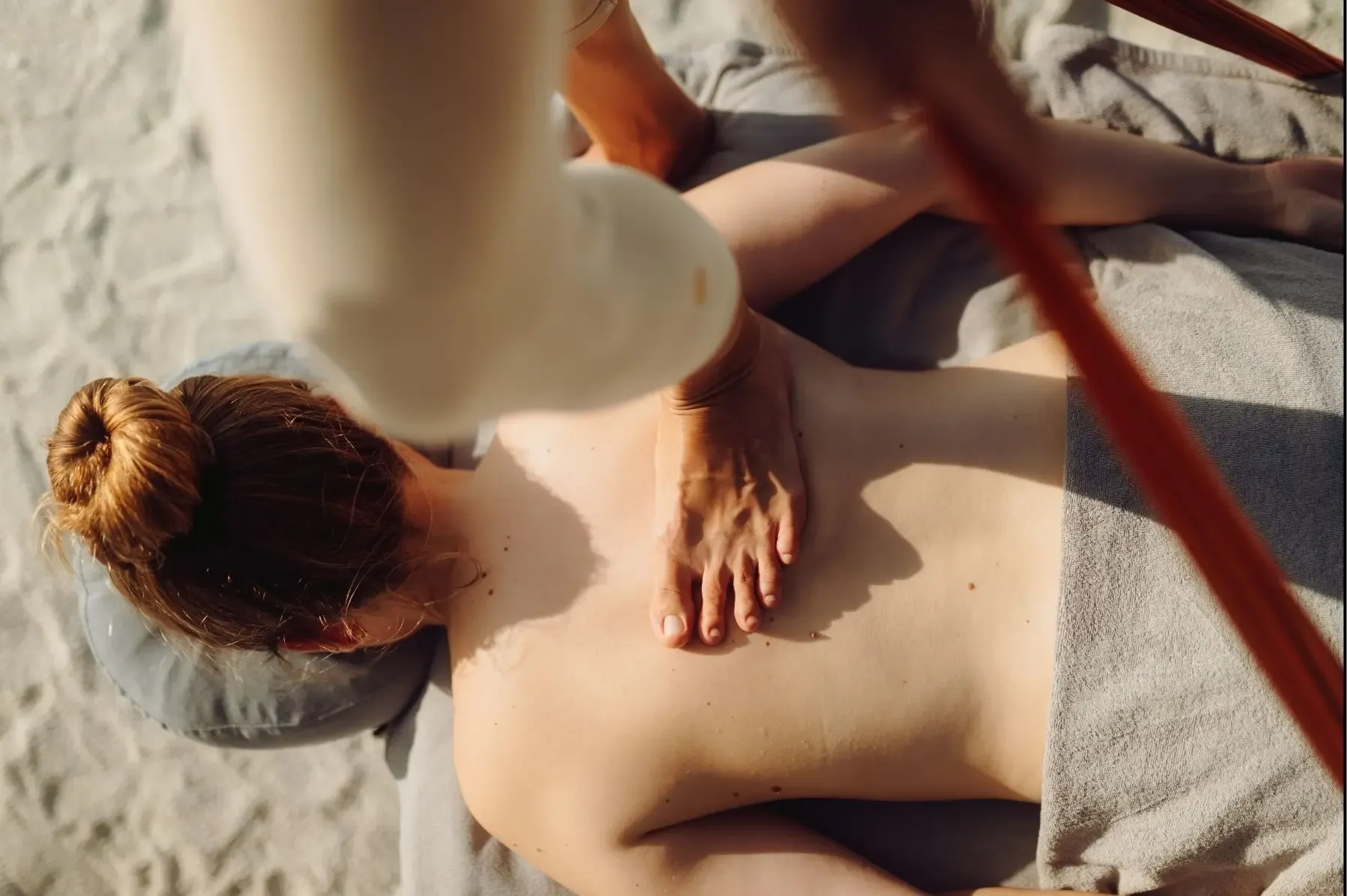 Practitioner applying foot-on bodywork to a client lying face down on a massage table