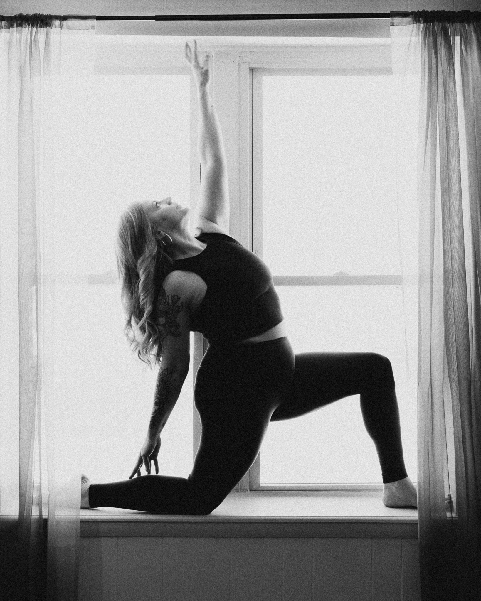 A yoga teacher in a deep backbend in front of a bright window