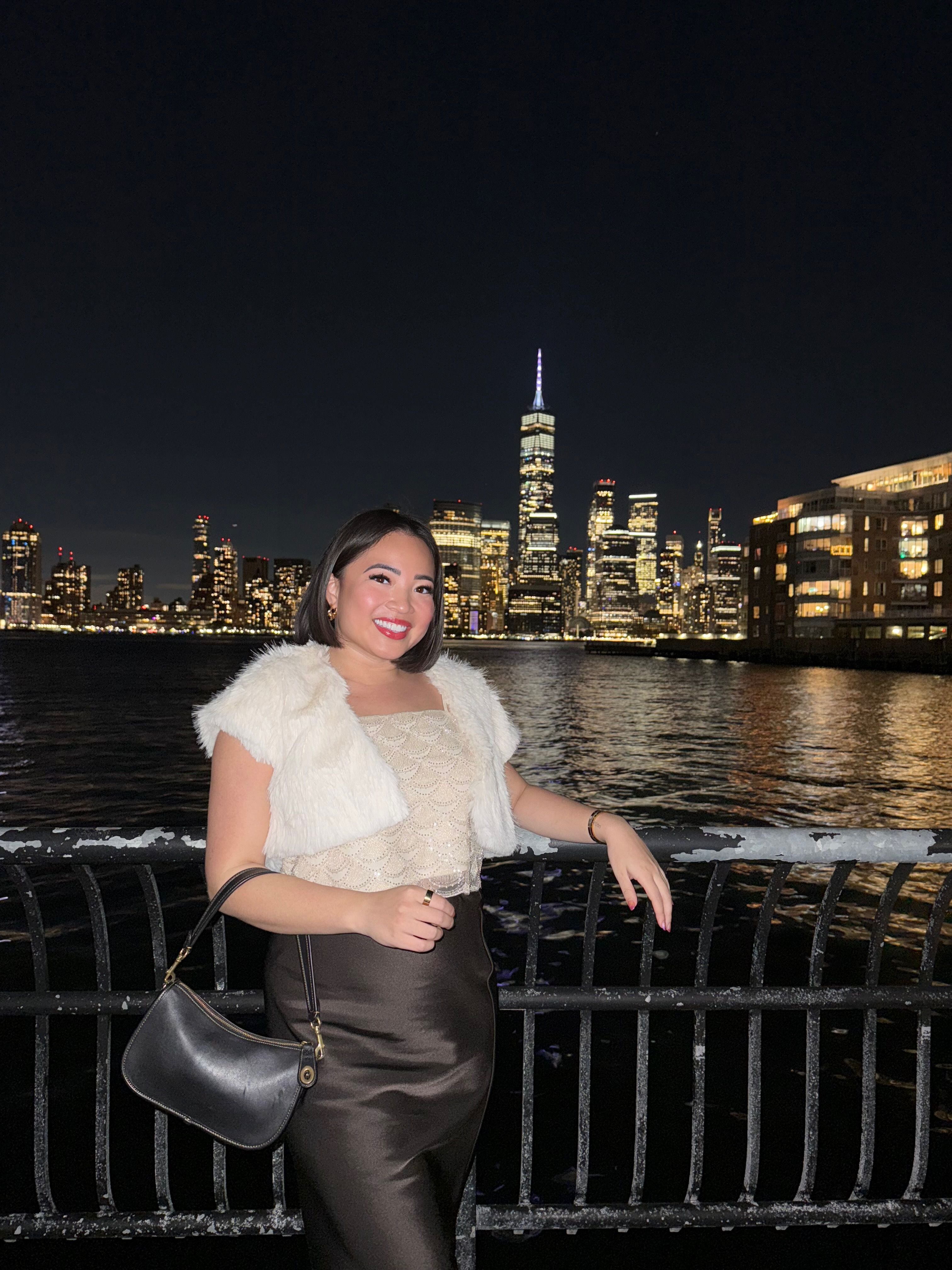 Megan Vasquez with the New York City skyline at night