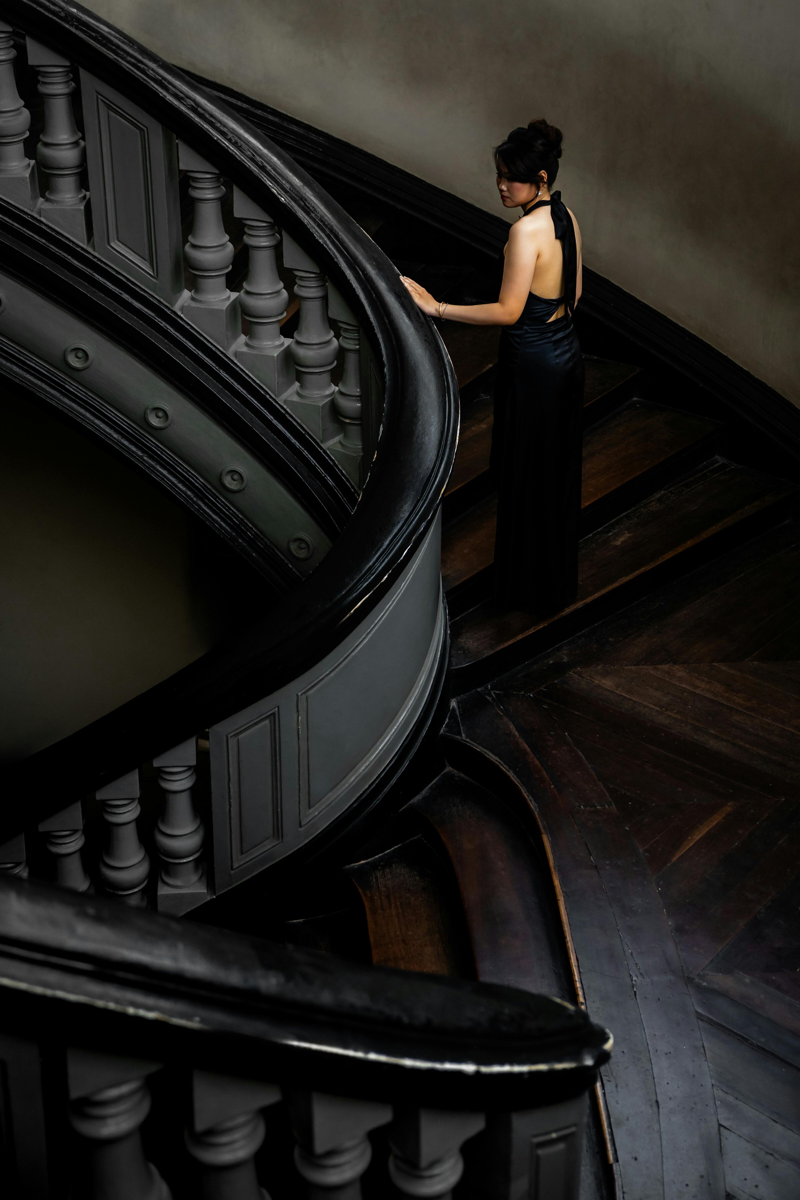 A woman on a dark spiral staircase