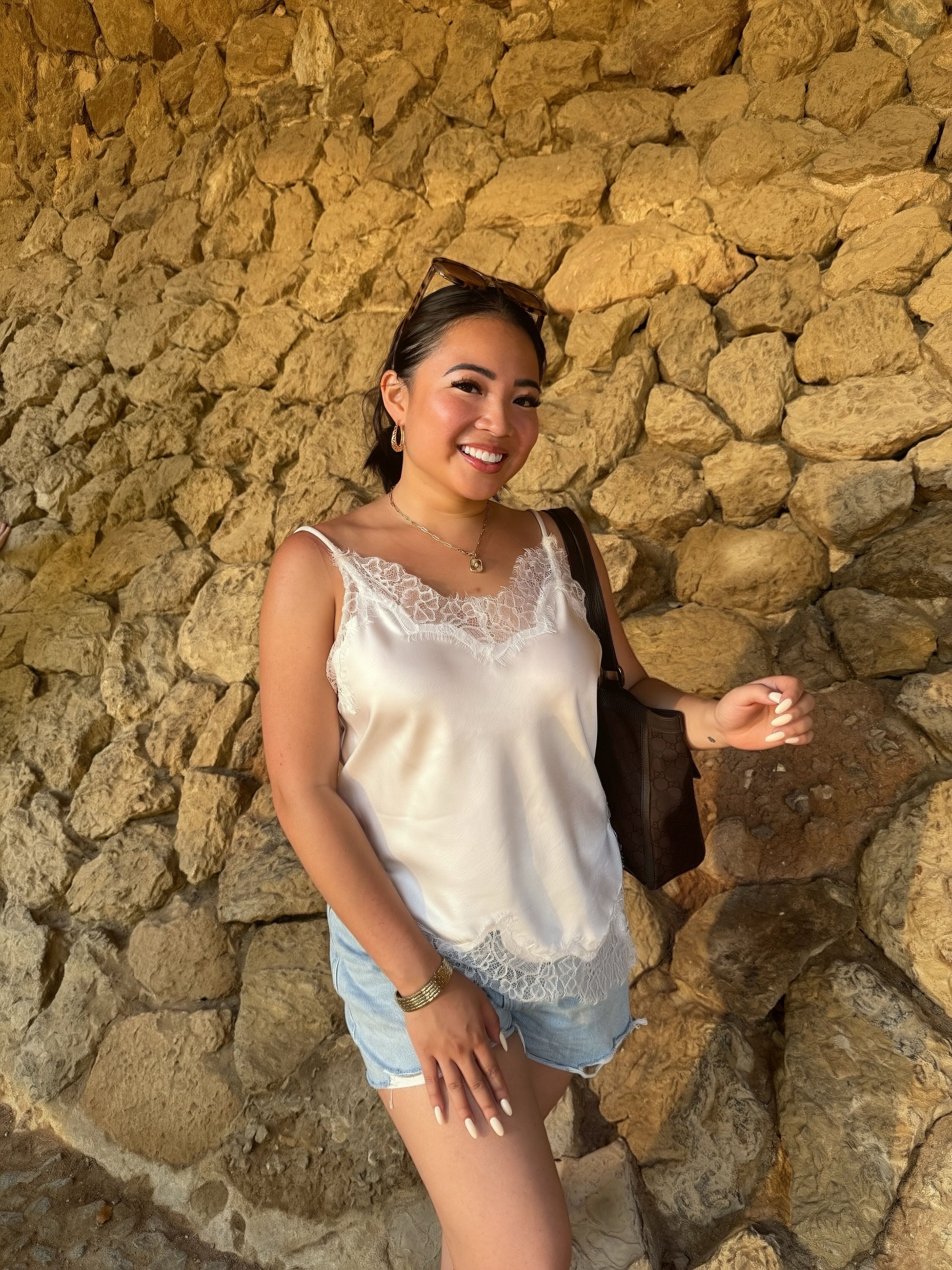 Megan in a white top against a stone wall