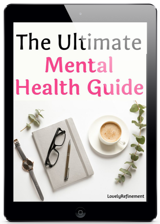 A promotional image of a black tablet displaying the cover of “The Ultimate Mental Health Guide” by Lovely Refinement. The cover uses large black and pink text on a clean white background. Below the title is a calm desk-style flat lay featuring a gray notebook, black eyeglasses, a pen, a wristwatch, a cup of coffee, and green eucalyptus stems. The overall design feels soft, organized, feminine, and wellness-focused.