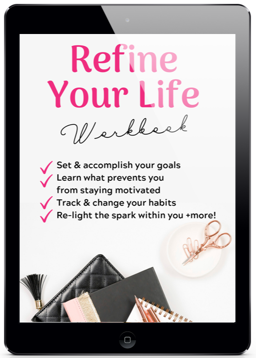 A promotional image of a black tablet displaying the cover of the “Refine Your Life Workbook.” The cover features large pink text reading “Refine Your Life” with the word “Workbook” in a black handwritten-style font beneath it. A checklist on the left highlights the workbook’s benefits: setting and accomplishing goals, learning what prevents motivation, tracking and changing habits, and reigniting personal inspiration. The bottom of the cover includes a feminine flat lay with a black quilted pouch, notebooks, pencils, and rose gold scissors on a clean white background.