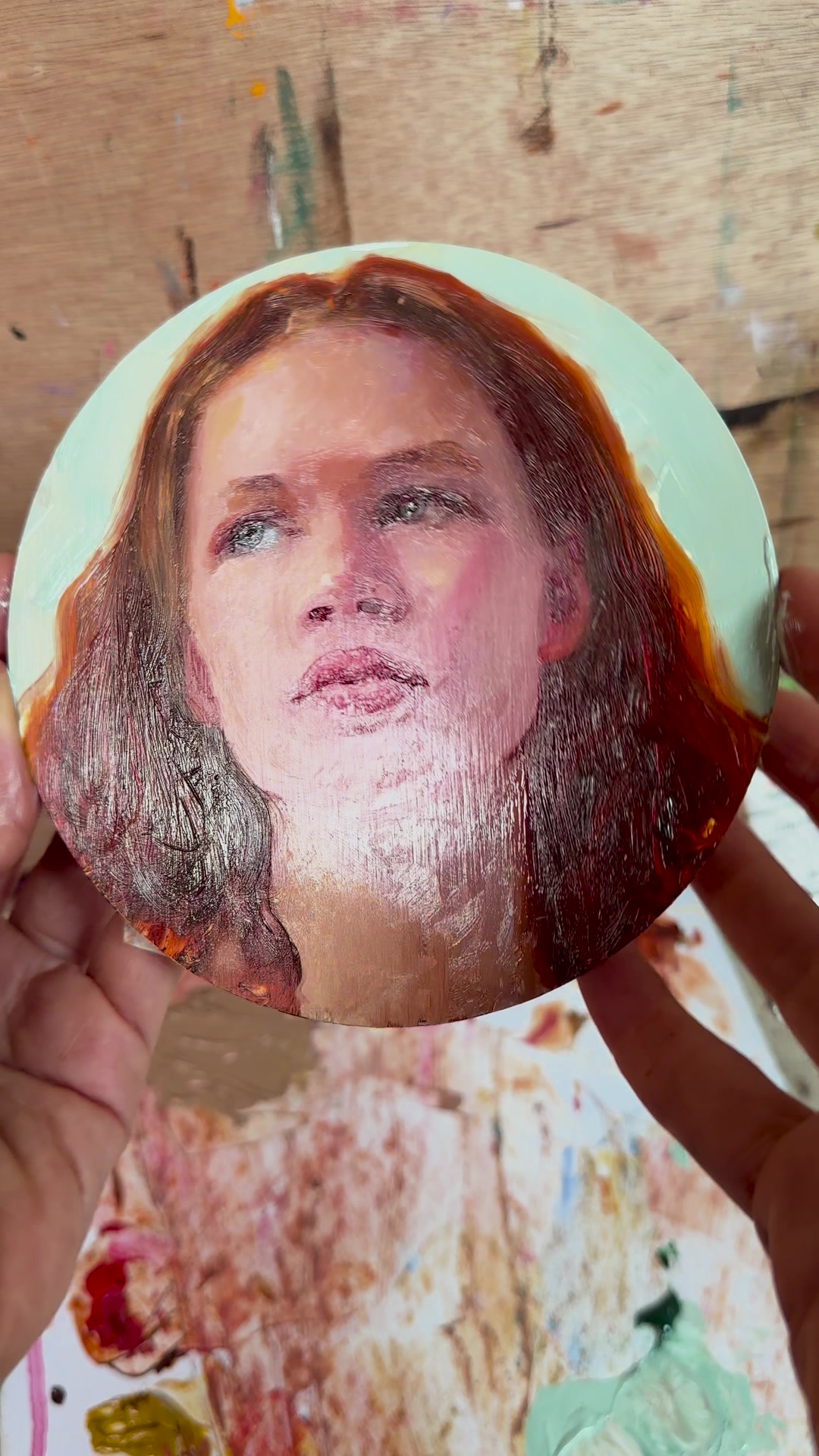 The finished portrait on aluminium, tilted so the paint catches the light