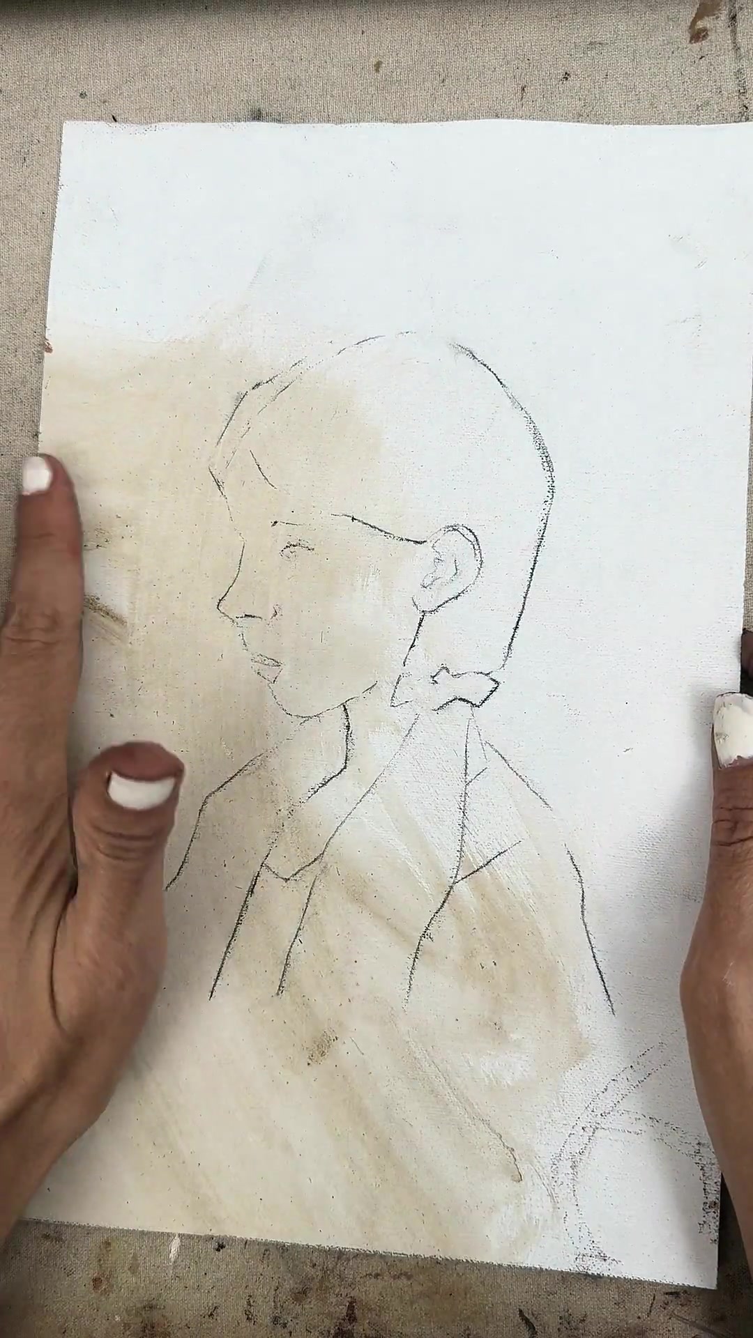 Lifting the tracing paper to reveal the lines on the canvas