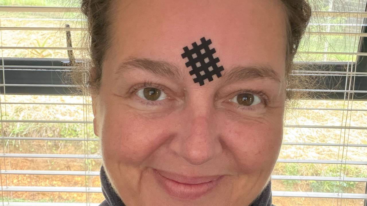 Ganzes Gesicht: Melanie, 51, Face-Yoga-Lehrerin, ungeschminkt mit Gittertape zwischen den Brauen
