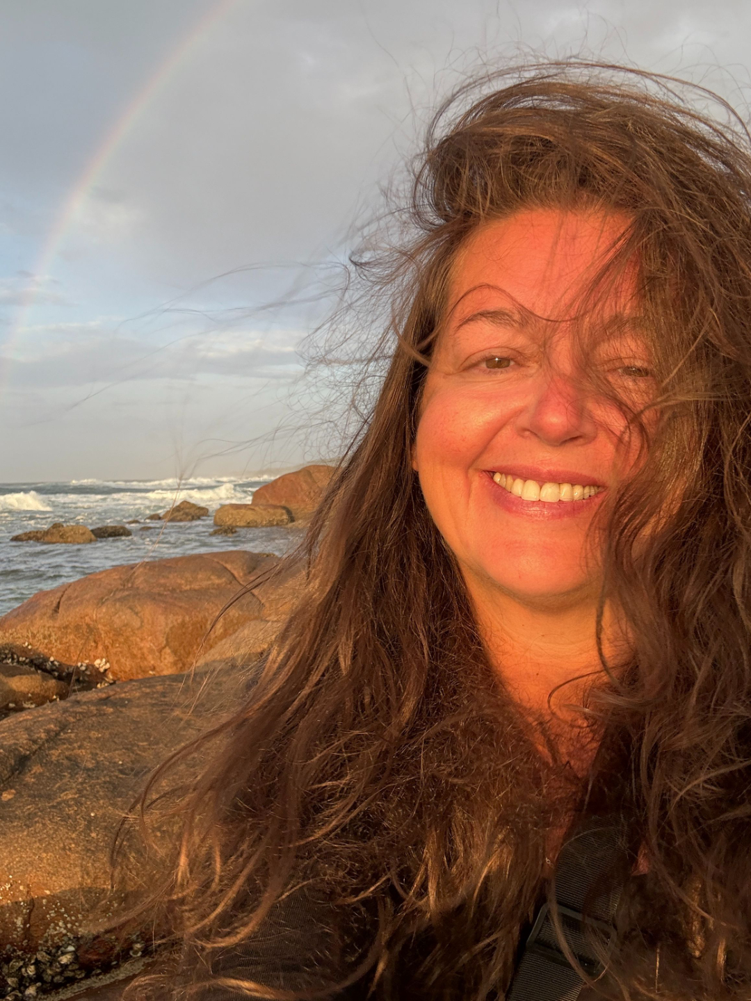 Face yoga teacher smiling outdoors by the sea